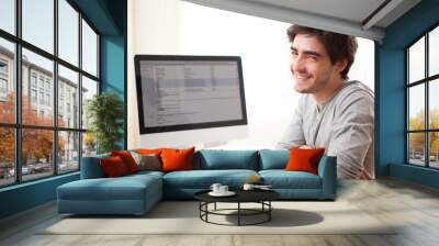 young smiling man in front of computer Wall mural