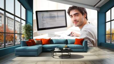 young smiling man in front of computer Wall mural