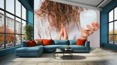 Female's hands apply cosmetic coconut oil Wall mural