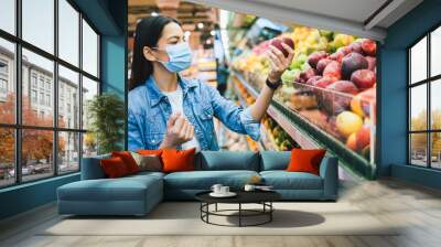 Young woman wearing protective face mask shopping Wall mural