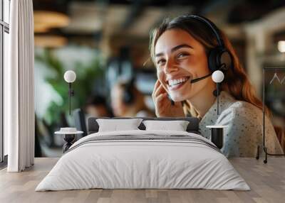 A cheerful woman wearing a headset engages with customers at a call center in a lively office environment Wall mural