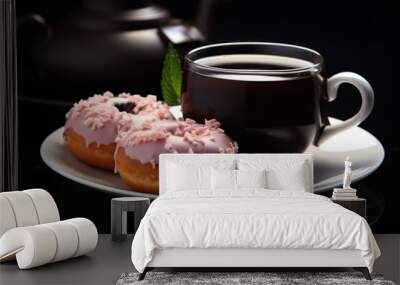 A cup of tea and two pink frosted donuts on a plate on a dark background. Wall mural