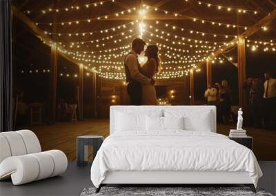 A bride and groom dance together in a dimly lit barn adorned with twinkling string lights during their wedding reception. Wall mural