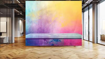 A clear, rectangular tabletop sits in front of a wall with a colorful abstract background. Wall mural