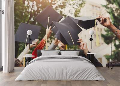 A group of graduates throwing graduation caps in the air Wall mural