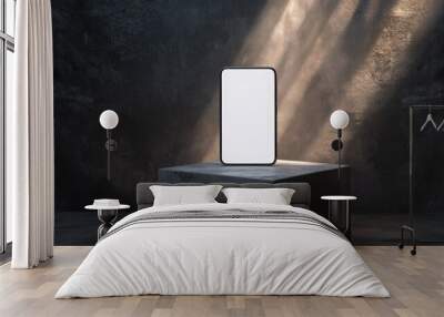 A sleek smartphone stands upright on a gray stone pedestal, illuminated by soft beams of light from above. The surrounding dark backdrop enhances its design, creating a striking visual effect. Wall mural