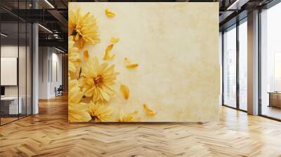 A vibrant arrangement of yellow flowers with delicate petals is placed on a soft, textured background, creating a cheerful and inviting atmosphere. The warm tones enhance the floral display. Wall mural