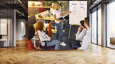 A woman is standing in front of a whiteboard, delivering a presentation to an audience. She gestures and speaks confidently, engaging the viewers with her content. Wall mural