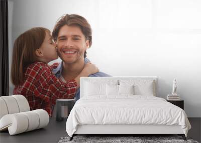 Adorable little girl kissing her happy father Wall mural