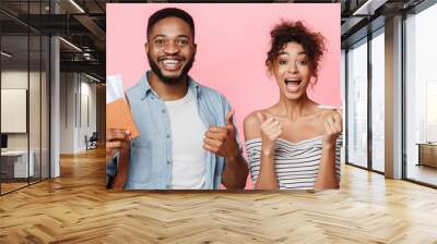 African-american couple holding flying tickets and showing thumbs up Wall mural