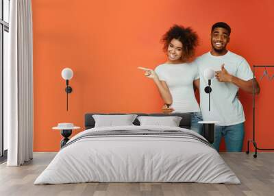 African American Couple Pointing Fingers At Copyspace, Orange Background, Panorama Wall mural