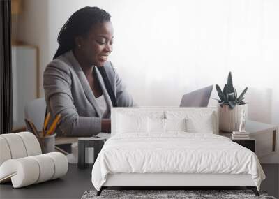 African american female employee using laptop at workplace in office Wall mural