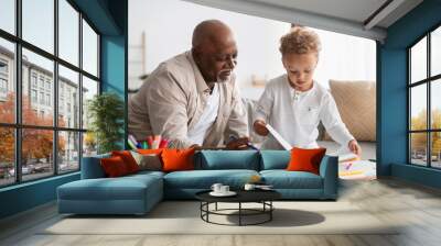 African American Little Boy Showing Drawings To Grandpa At Home Wall mural