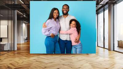 African American man hugging his wife and smiling daughter Wall mural