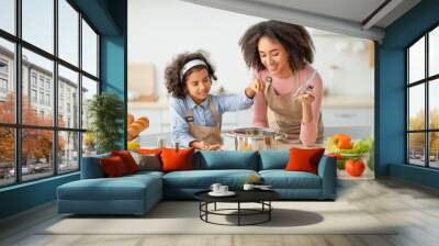 African american mom teaching daughter how to prepare soup Wall mural