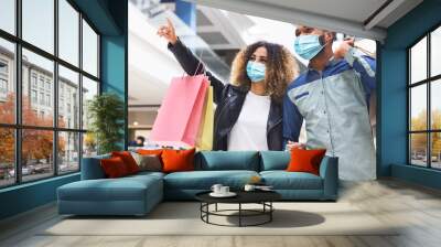 African couple in face masks doing shopping in city mall Wall mural