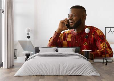 African Freelancer Guy Talking On Cellphone And Enjoying Coffee At Home Office Wall mural