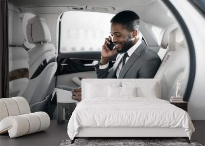 Afro businessman arranging his affairs in the car Wall mural