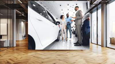 Afro Salesman Selling Car To Customers Standing In Dealership Showroom Wall mural