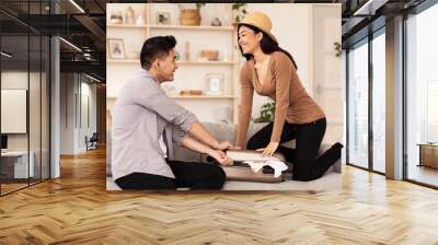 Asian Couple Packing Suitcase Preparing For Vacation At Home Wall mural