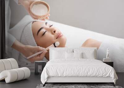 Attractive young asian woman receiving skin treatment at spa center Wall mural