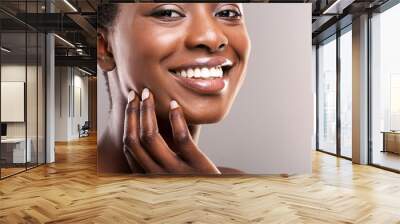 Beautiful black girl with perfect smooth skin touching her face Wall mural