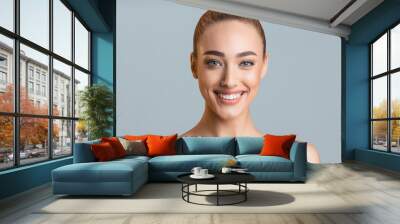 Beauty portrait. Beautiful woman with perfect smile and clean skin over grey studio background Wall mural