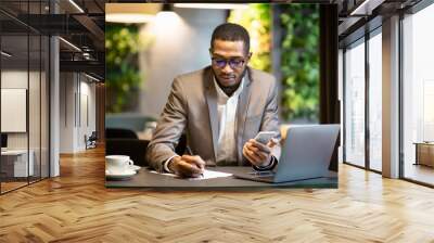 Black business man taking notes holding phone Wall mural