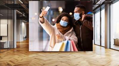 Black couple in masks taking selfie after shopping Wall mural