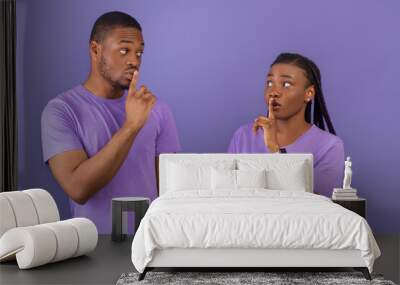 Black couple puting finger on lips, making hush sign Wall mural