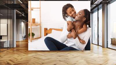 Black girl embracing her mom at home Wall mural