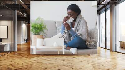 Black girl having flu, blowing nose and checking body temperature Wall mural