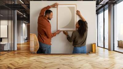 Black Husband And Wife Hanging Picture In Frame At Home Wall mural