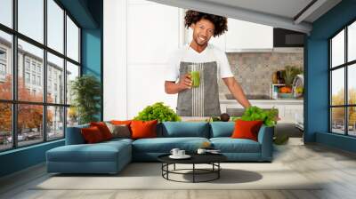 Black Man Holding Glass Of Green Vegetable Juice In Kitchen Wall mural