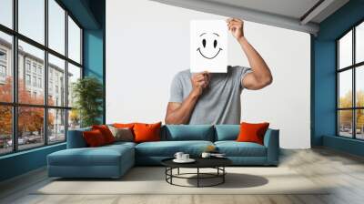 Black man holding paper with smiley face Wall mural