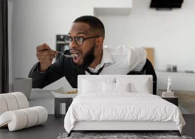 Black man rushing to work eating cereal at home Wall mural