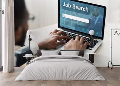 Black man using laptop with job search engine on screen Wall mural