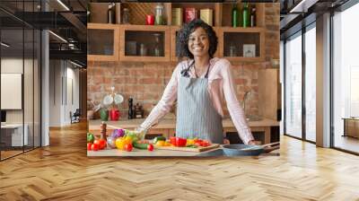 Black woman cooking healthy salad at kitchen, smiling at camera Wall mural