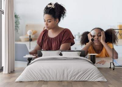 Black woman freelancer working from home, bored daughter sitting by Wall mural