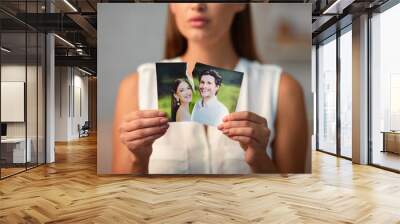 Breakup Concept. Sad Girl Ripping Wedding Photo With Ex-Husband After Divorce Indoor. Selective Focus Wall mural