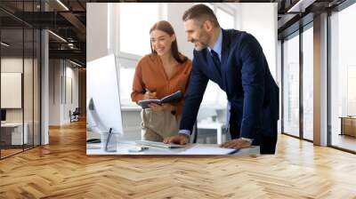 Business colleagues using computer and communicating, working on business project together, discussing ideas in office Wall mural