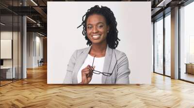 Business Lady Smiling At Camera Holding Eye Glasses On White Wall mural