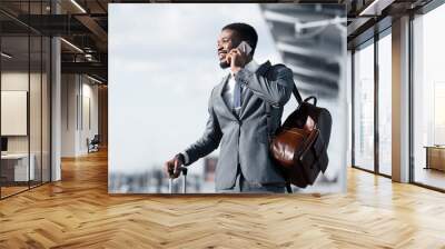 Business Talk. African Man Talking on Phone at Airport and Waiting Taxi Wall mural