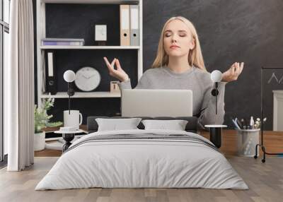 Business woman meditating in office Wall mural