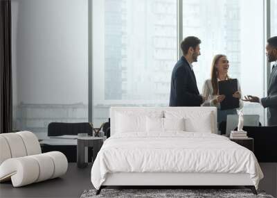 Businesspeople talking in office, standing against window Wall mural