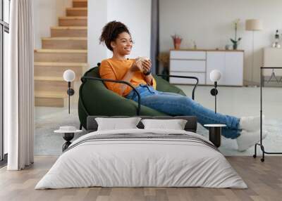 Calm black woman having rest at home drinking coffee Wall mural