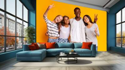 Carefree international students having fun over yellow background Wall mural