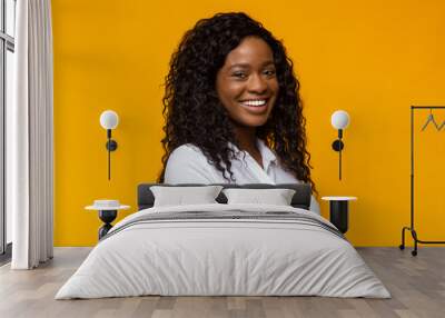 Cheerful african american girl over yellow background Wall mural