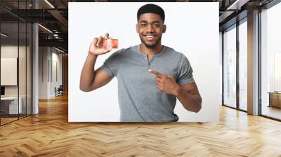 Cheerful african-american man pointing at credit card Wall mural