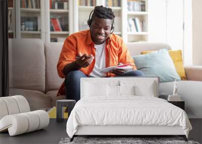 Cheerful african american man student attending webinar, using laptop Wall mural